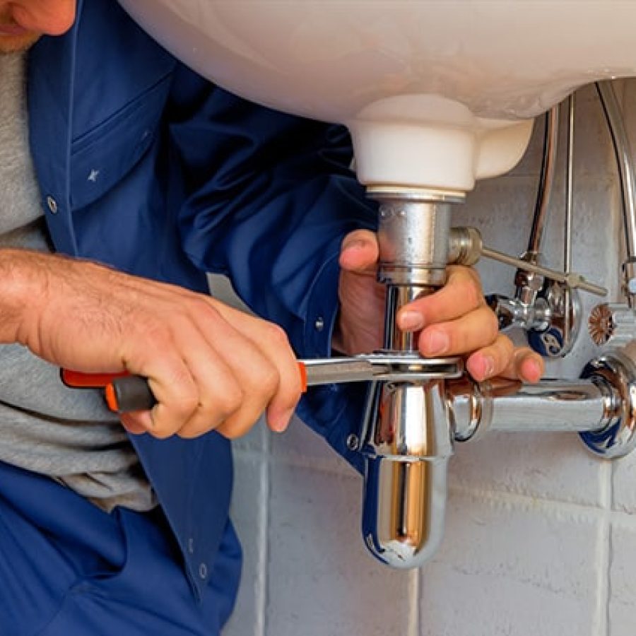 Professional plumber fixing water heater in Linda CA home